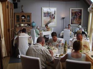 un groupe de personnes assises à table dans un restaurant dans l'établissement Hotel Hooghuys, à Hamont