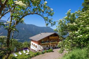 una casa en una colina con sillas y árboles en Thalerhof Tiers en Tires