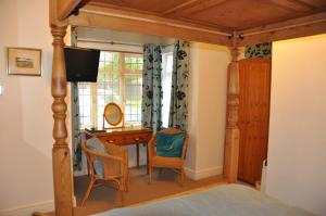 a bedroom with a bed with a desk and a television at Walcot House in Fawley