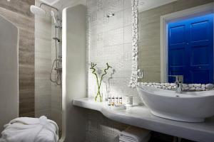 baño con lavabo blanco y puerta azul en Efi Studios, en Pollonia