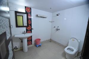 a bathroom with a sink and a toilet and a mirror at Hotel Vaishnavi in Jaipur