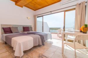 a bedroom with a bed and a table and a balcony at Cabanas Ria Sea View By Algartur in Cabanas de Tavira