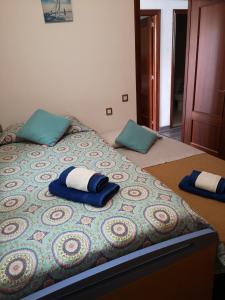 a bed with two blue pillows on top of it at Camarotes 17 y 28 in Las Palmas de Gran Canaria