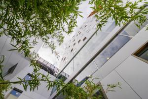 a glass building with trees in front of it at HF Fénix Urban in Lisbon +21 photos