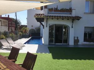 ein Haus mit einem Garten mit zwei Stühlen und einem Pool in der Unterkunft Villa Masnou Homelydays in El Carrer del Canonge