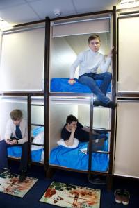 quatro rapazes sentados em beliches num comboio em Никитская капсула - сердце Москвы em Moscou