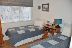 a bedroom with two beds and a desk and a window at Walcot House in Fawley