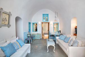 a living room with a white couch and blue pillows at EverBlue Cave house by Thireon in Oia