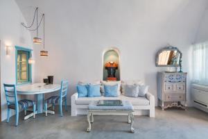 a living room with a couch and a table at EverBlue Cave house by Thireon in Oia +15 photos