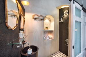 y baño con bañera, lavabo y espejo. en EverBlue Cave house by Thireon en Oia