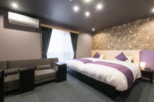 ein Schlafzimmer mit einem großen Bett und einer Couch in der Unterkunft Stay SAKURA Kyoto Zen in Kyoto