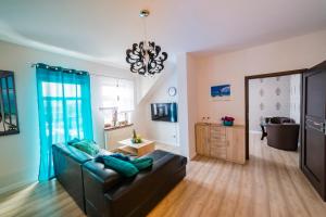 - un salon avec un canapé et un lustre dans l'établissement Top Apartamenty, à Kielce