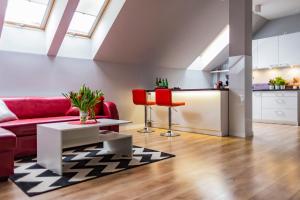 - un salon avec un canapé rouge et une table dans l'établissement Top Apartamenty, à Kielce