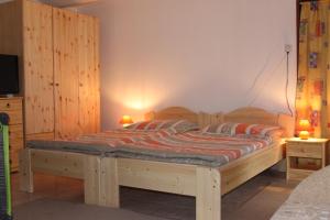 1 dormitorio con 1 cama de madera y 2 lámparas en Orbán Porta, en Szalafő