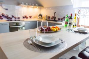 a table with glasses of wine and a plate of fruit at Top Apartamenty in Kielce