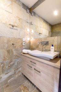 La salle de bains est pourvue d'un lavabo et d'un mur en pierre. dans l'établissement Apartament z Widokiem, à Poznań