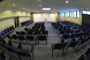 een lege kamer met stoelen en een collegezaal bij Dobre Miejsce Dom Rekolekcyjny in Warschau