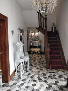 ein Wohnzimmer mit einer Treppe und einem Kronleuchter in der Unterkunft Abbey House in Llandudno