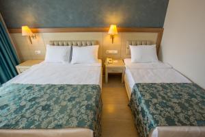 シダにあるSide Aquamarin Resort & Spaのベッド2台とデスクが備わるホテルルームです。