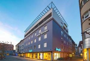 un grand bâtiment avec un panneau sur son côté dans l'établissement Hotel Central, à Bregenz