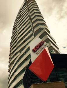 a tall building with a sign in front of it at Flat Kariris Home Service in Juazeiro do Norte