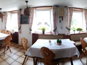 a dining room with two tables and two windows at Gasthaus zum Kreuz in Grafenhausen