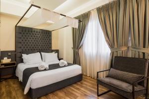 雅典的住宿－雅典衛城行政套房公寓，配有一张床和一把椅子的酒店客房