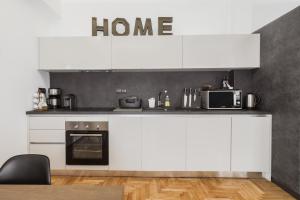 kuchnia z białymi szafkami i mikrofalówką w obiekcie Acropolis Executive Suite w Atenach