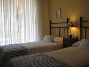 桑克森克索的住宿－Residencial Progreso Sanxenxo，一间卧室设有两张床和窗户。
