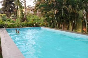 a person in a swimming pool in a large blue pool at Asian Golden Sands - S7 & S8 in Benaulim