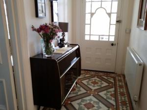 a hallway with a table with a vase of flowers on it at Beach Lodge in Bournemouth