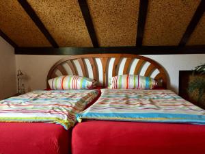 a bed with a wooden headboard and two pillows at Hegau-Lounge-Bodensee in Mühlhausen-Ehingen