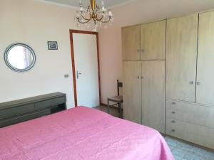 サン·ヴィンチェンツォにあるAppartamento ''La Piana''のベッドルーム1室(ピンクベッド1台、シャンデリア付)