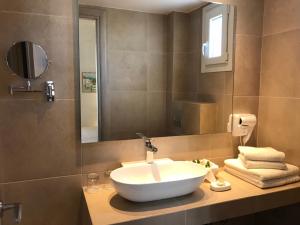 a bathroom with a bowl sink and a mirror at Sailor's Nautical Concept in Spetses