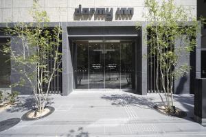 大阪多美迎大阪谷町酒店的门前有两棵树的建筑