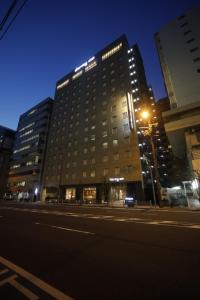 a tall building with a street light in front of it at Dormy Inn Osaka Tanimachi in Osaka