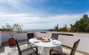 a table with a plate of food on a balcony at Apartment Deni in Krk