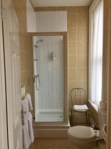ein Bad mit einer Dusche und einem WC in der Unterkunft Balmoral in Skegness