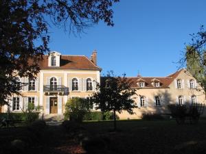 a large white building with a balcony on a yard at Domaine de Sainte Anne in Venoy