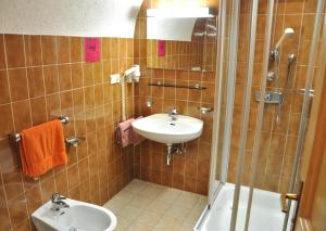 a bathroom with a sink, toilet and bathtub at Hotel Grauer Bär in Bressanone
