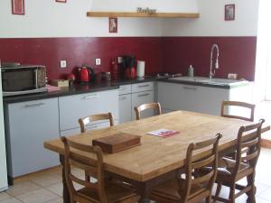 a kitchen with a wooden table and some chairs at Gite en Forterre in Druyes-les-Belles-Fontaines