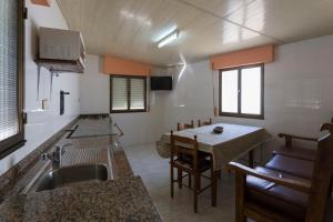una pequeña cocina con fregadero y mesa en Casa Aniceto, en Taramundi