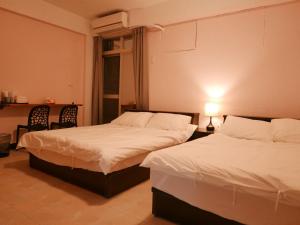 Ein Bett oder Betten in einem Zimmer der Unterkunft 市區背包客棧-有套房及包棟