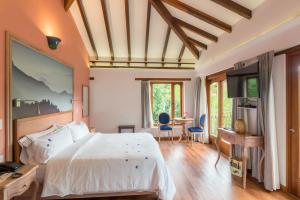 a bedroom with a bed and a table with chairs at La Casa Del Arbol Hotel Boutique Villa de Leyva in Villa de Leyva +52 photos