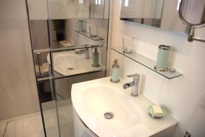 un bagno bianco con lavandino e specchio di L'Art Studio hyper centre a La Rochelle Altre 28 foto
