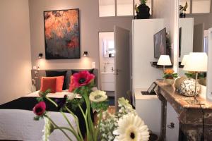 L'Art Studio hyper centre في لا روشيل: غرفة نوم بسرير وزهور في غرفة