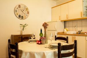 a kitchen with a table with a clock on the wall at Apartmani Eškinja in Biograd na Moru