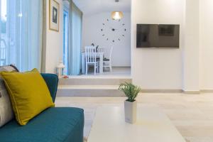 a living room with a couch and a clock on the wall at Apartment Novak in Budva