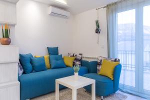 a blue couch and two chairs in a living room at Apartment Novak in Budva