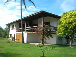 una casa blanca con una palmera en el patio en Vila Kitepirinha, en Flecheiras